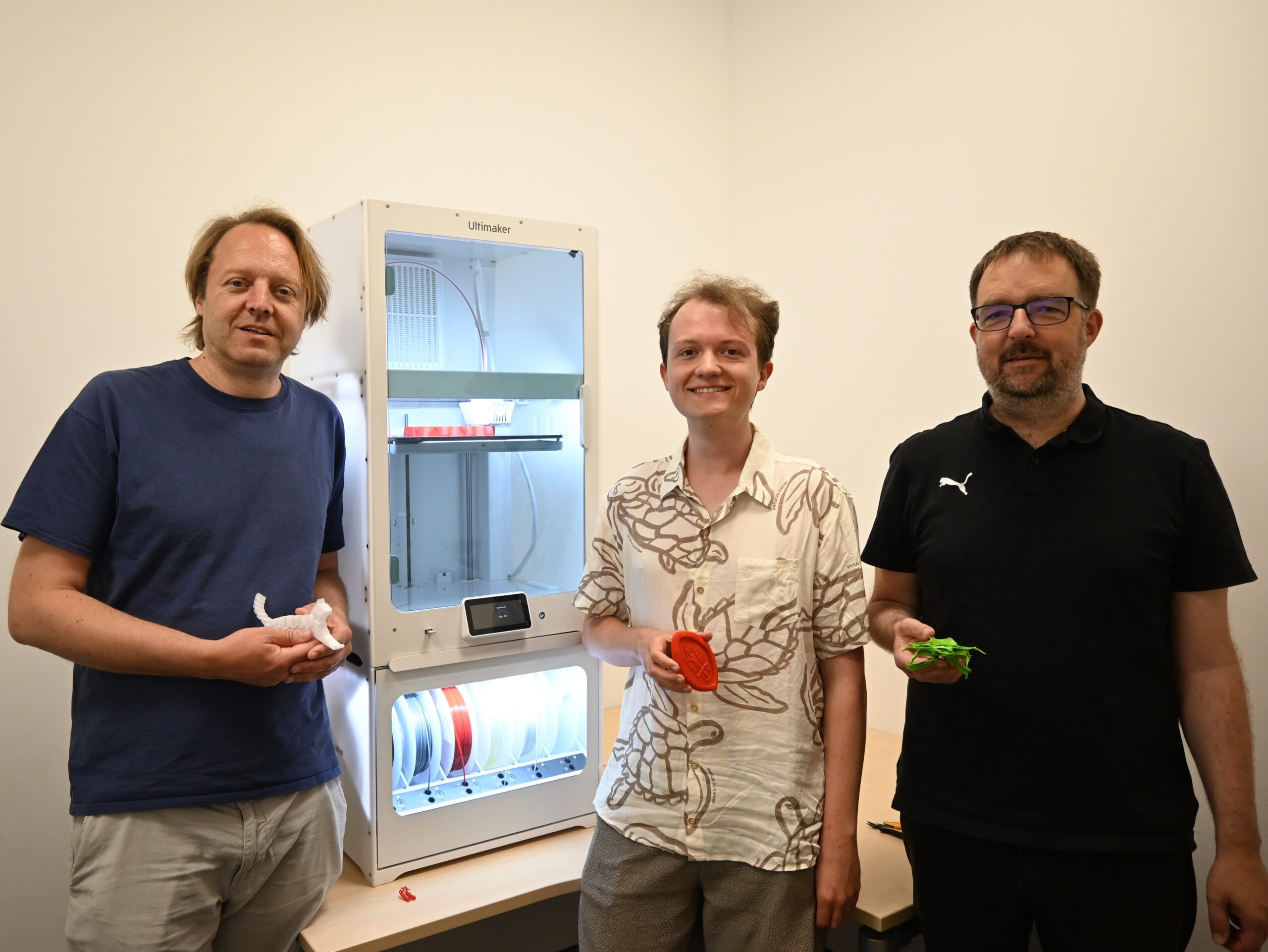 Das Foto zeigt von links Dr. Carl-Christian Fey, den Geschäftsführer des DigiLLab, Kai Weeber, den Mitarbeiter im Projekt New Normal, und Prof. Dr. Ingo Kollar, Professor für Pädagogische Psychologie und wissenschaftlicher Leiter des DigiLLab, im 3D-Teaching Lab vor dem 3D-Drucker